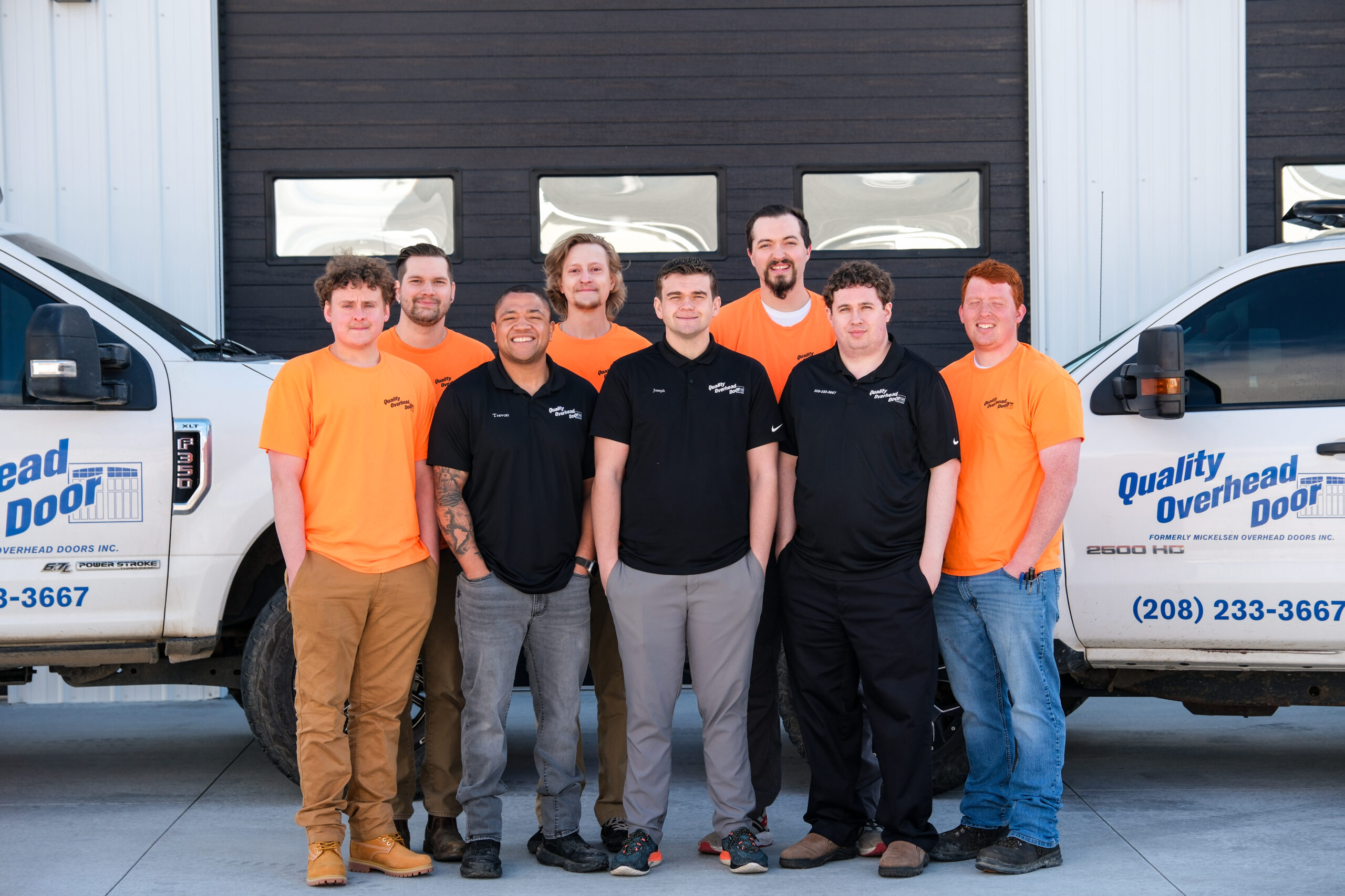 Group of technicians posing by service trucks